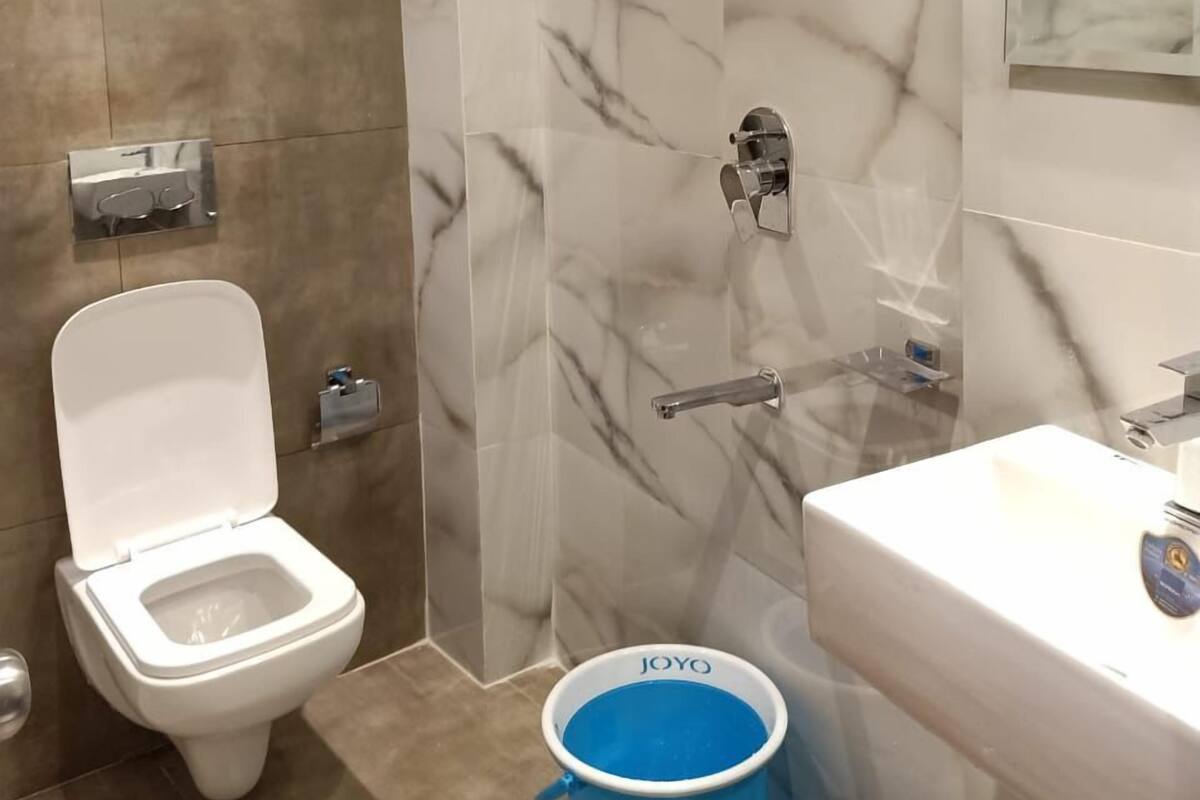 Un baño moderno con inodoro, ducha y lavamanos.