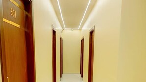 A hallway with a wooden door labeled "301" and a handrail on the right. - Powai Inn (Mumbai)