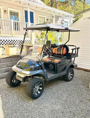 Carrinho de golfe estacionado em uma entrada.