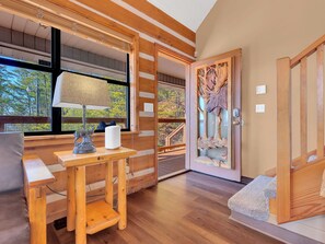 Ein Holzinterieur mit Schreibtisch, Lampe und einer Tür, verziert mit einem geschnitzten Hirschkopf.
