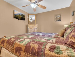 A bedroom with a large bed, a ceiling fan, a dresser, and a television on the wall. - Breathtaking Views | Close To Dollywood | Hot Tub | Pool Table | WiFi (Sevierville)