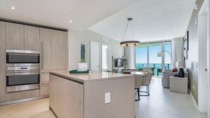 Une cuisine moderne dotée d’appareils électroménagers intégrés, un coin repas avec vue et un vaste espace de vie.