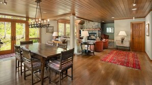 A spacious living room with a wooden ceiling, a dining area with a large table and chairs, and a fireplace. - Residence #31 3 Bedroom Home (Snowmass Village)