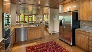 A modern kitchen with wooden cabinets, stainless steel appliances, and a central island. - Residence #31 3 Bedroom Home (Snowmass Village)
