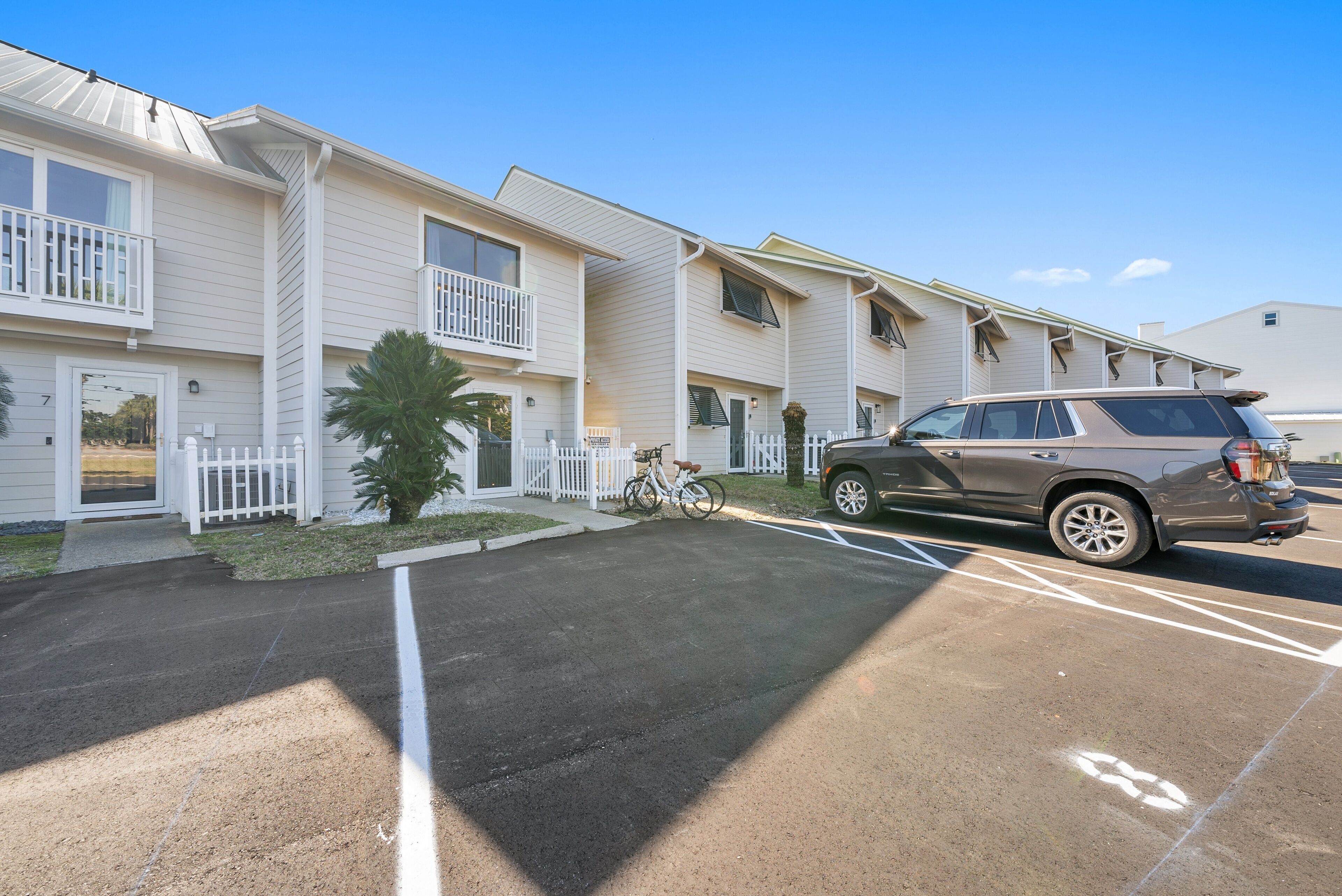 A row of two-story buildings with a parking lot in front.