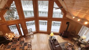 Una habitación amplia con una gran mesa de madera para comer, varias sillas, un sofá y una chimenea.