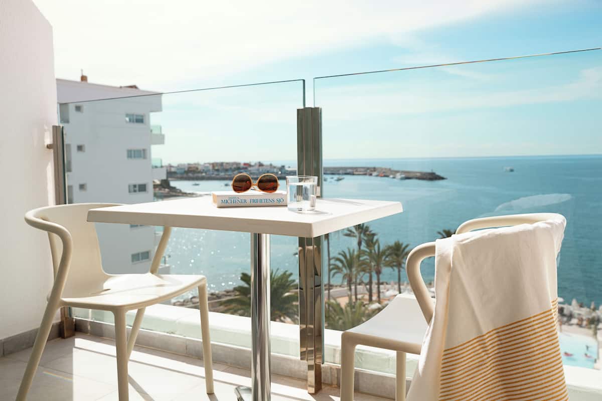 Un balcon avec une table et des chaises, une paire de lunettes de soleil et un livre intitulé « MICHENER PRINTERS SIO ».