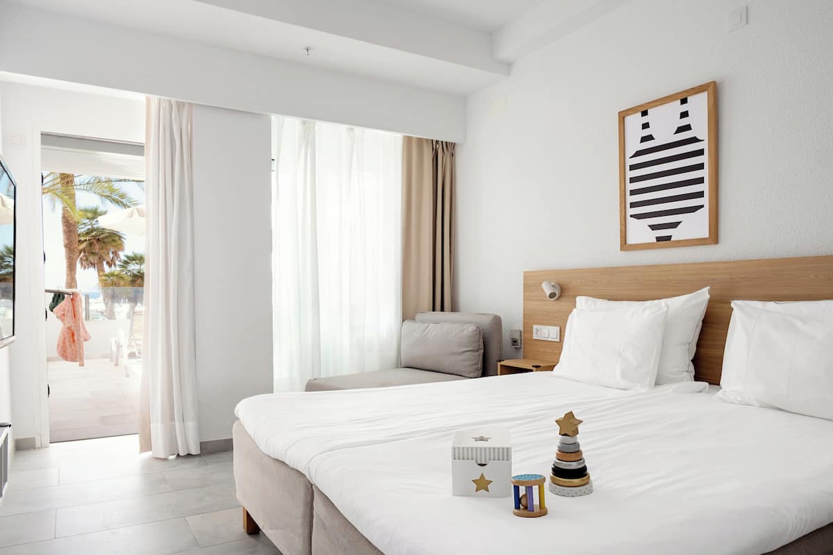 Une chambre d’hôtel avec un grand lit, une tête de lit en bois, une table de chevet et un tableau encadré au mur.