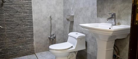 Une salle de bain avec des toilettes, un lavabo et une douche.