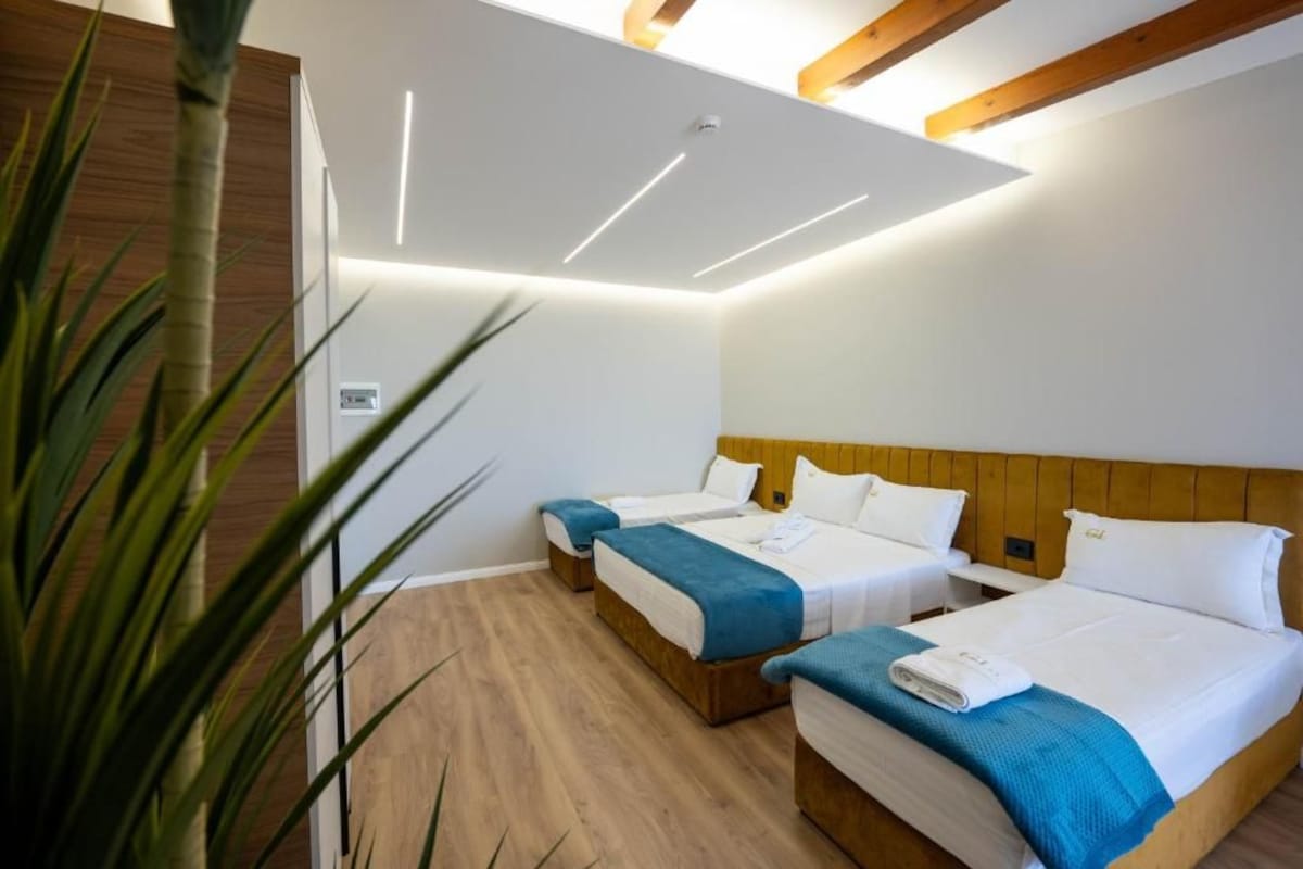 A hotel room with two beds, wooden headboards, and a ceiling with recessed lighting.