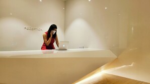 Et receptionsområde med moderne design, en bærbar computer på disken og en væg med ordet 