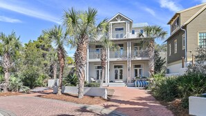 A two-story house with a balcony, surrounded by palm trees and a brick pathway. - Top Location on 30A Bordering Rosemary Beach with Private Pool and Beach (Inlet Beach)