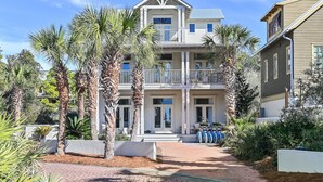 A two-story building with a balcony, surrounded by palm trees and a pathway leading to the entrance. - Top Location on 30A Bordering Rosemary Beach with Private Pool and Beach (Inlet Beach)