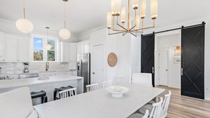 A modern kitchen with white cabinetry, a large island, and a chandelier. - Top Location on 30A Bordering Rosemary Beach with Private Pool and Beach (Inlet Beach)