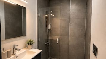 Een douche, een haardroger, pantoffels, handdoeken