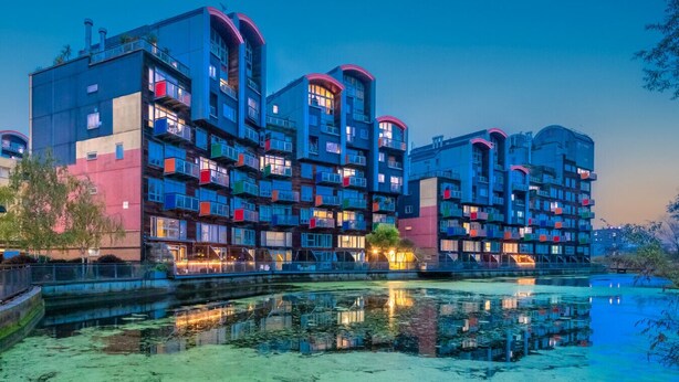 A modern multi-story hotel with balconies and a waterfront view. - Lovely 3BD Flat, Parking, sleeps SIX close to O2 (London)