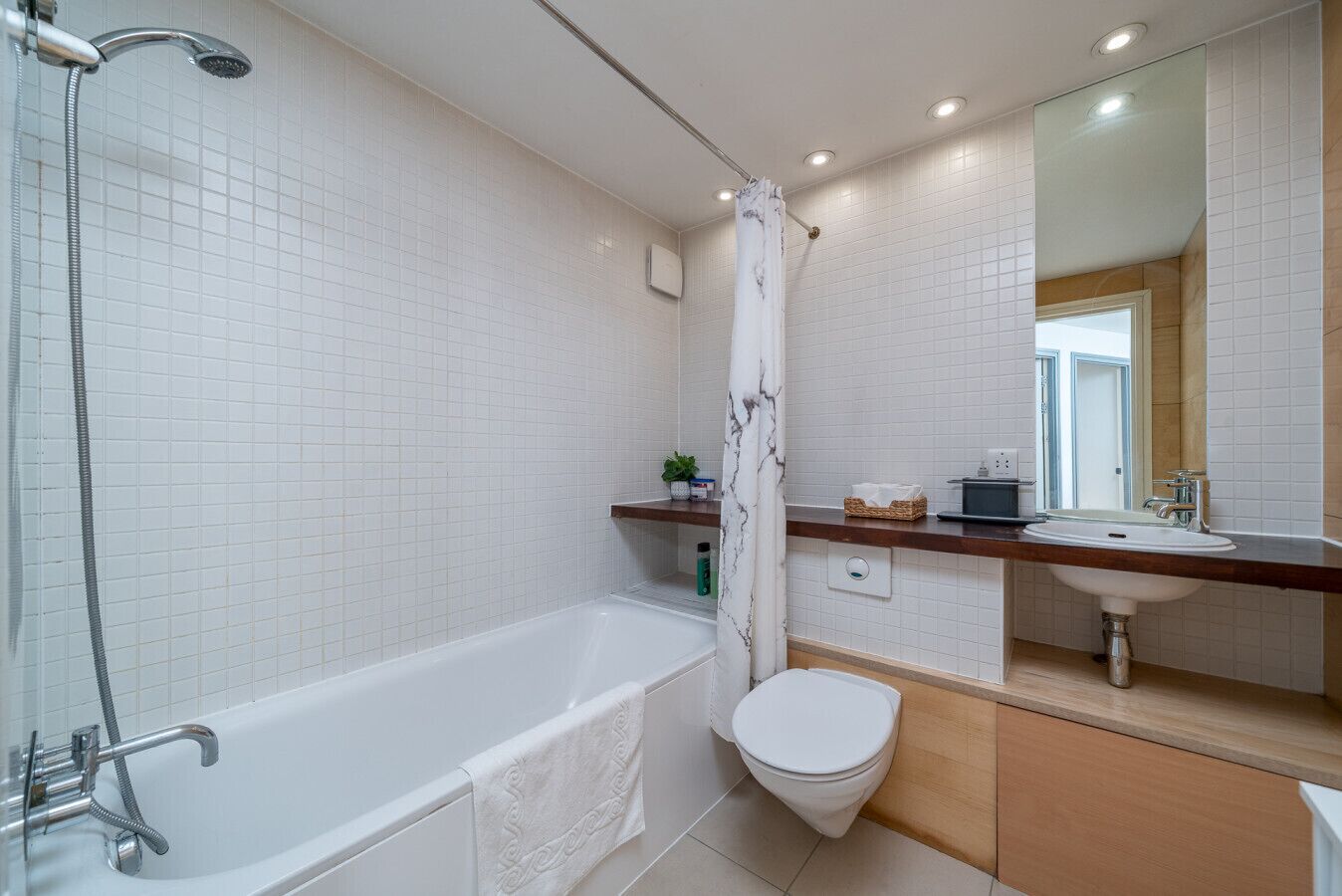 A modern bathroom with a bathtub, toilet, and sink.