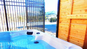 Un jacuzzi con vista a montañas y una pared de madera.