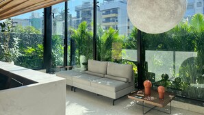 Un saló modern amb un sofà gran, una taula de centre i un llum penjant.