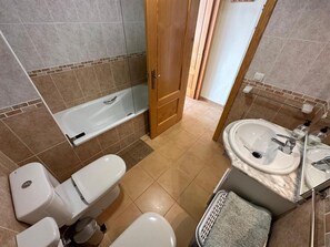 A bathroom with a bathtub, toilet, sink, and shower. - Apartamento Playa Sol A - Apartment with pool in Vinaròs (Vinaròs)