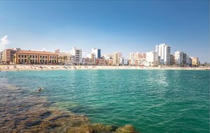 A coastal cityscape with a beach and a row of buildings. - Apartamento Playa Sol A - Apartment with pool in Vinaròs (Vinaròs)