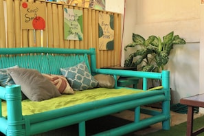 Relax in a cozy space with a comfortable sofa, motivational signs, and a lush green plant.