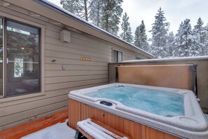 A hot tub outside a building with a wooden deck and a bench. - Sunriver Cabin/Hot tub/AC/Pet Friendly/Ping Pong (Sunriver)