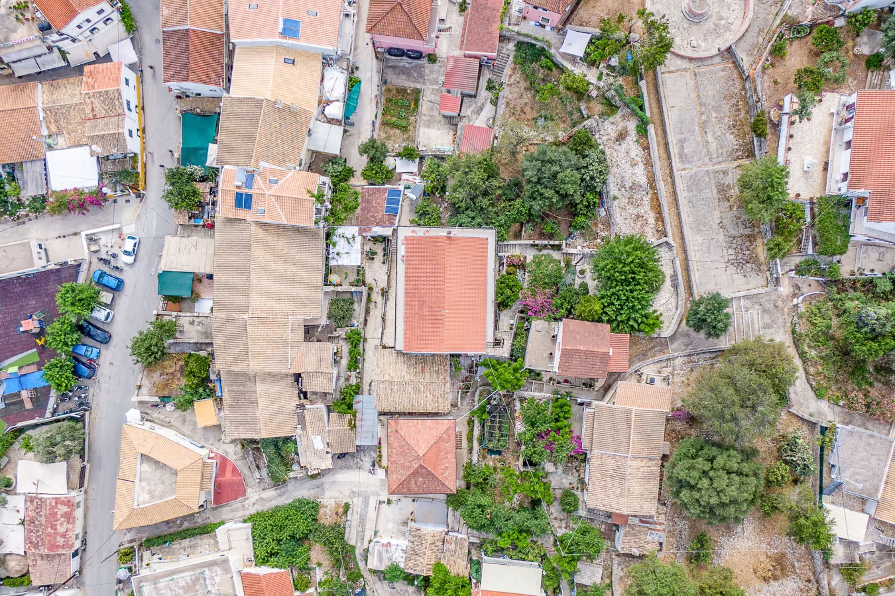 Une vue aérienne d’un quartier résidentiel caractérisé par des maisons très rapprochées les unes des autres, des rues étroites et une végétation abondante.