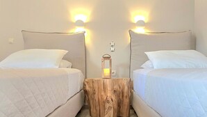 A hotel room with two beds, a wooden nightstand, and wall-mounted lights. - Corfu Apt in Gaios With 1 Bedrooms and 1 Bathrooms (Paxos)