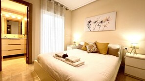 A hotel room with a bed, nightstands, a mirror, and a painting on the wall.