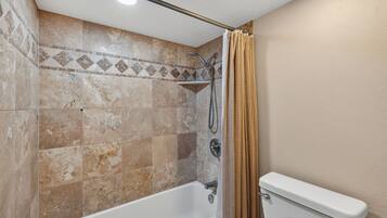 Un baño con ducha, bañera y retrete.