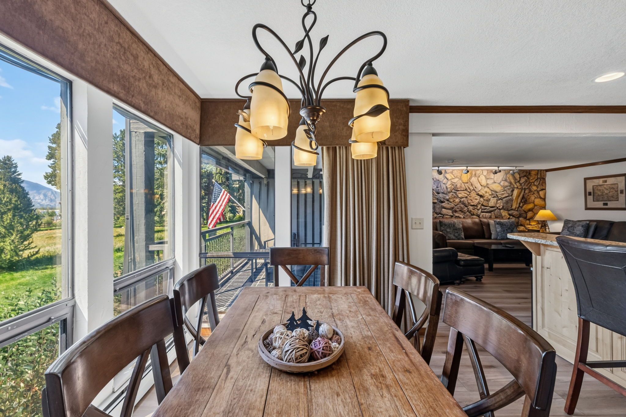 A dining area with a wooden table, chairs, and a chandelier.