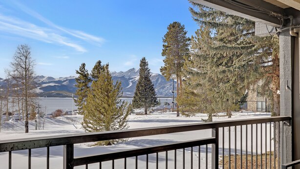 A balcony with a view of snow-covered mountains and a lake. - Stunning 2BR on Lake Dillon w/ Pool and Concert Access! (Dillon)