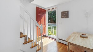 Ein modernes Interieur mit Treppe, einer zur Außenseite führenden Tür und einem Willkommen-Schild.