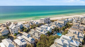 Uma área residencial costeira com casas, praia e piscina.