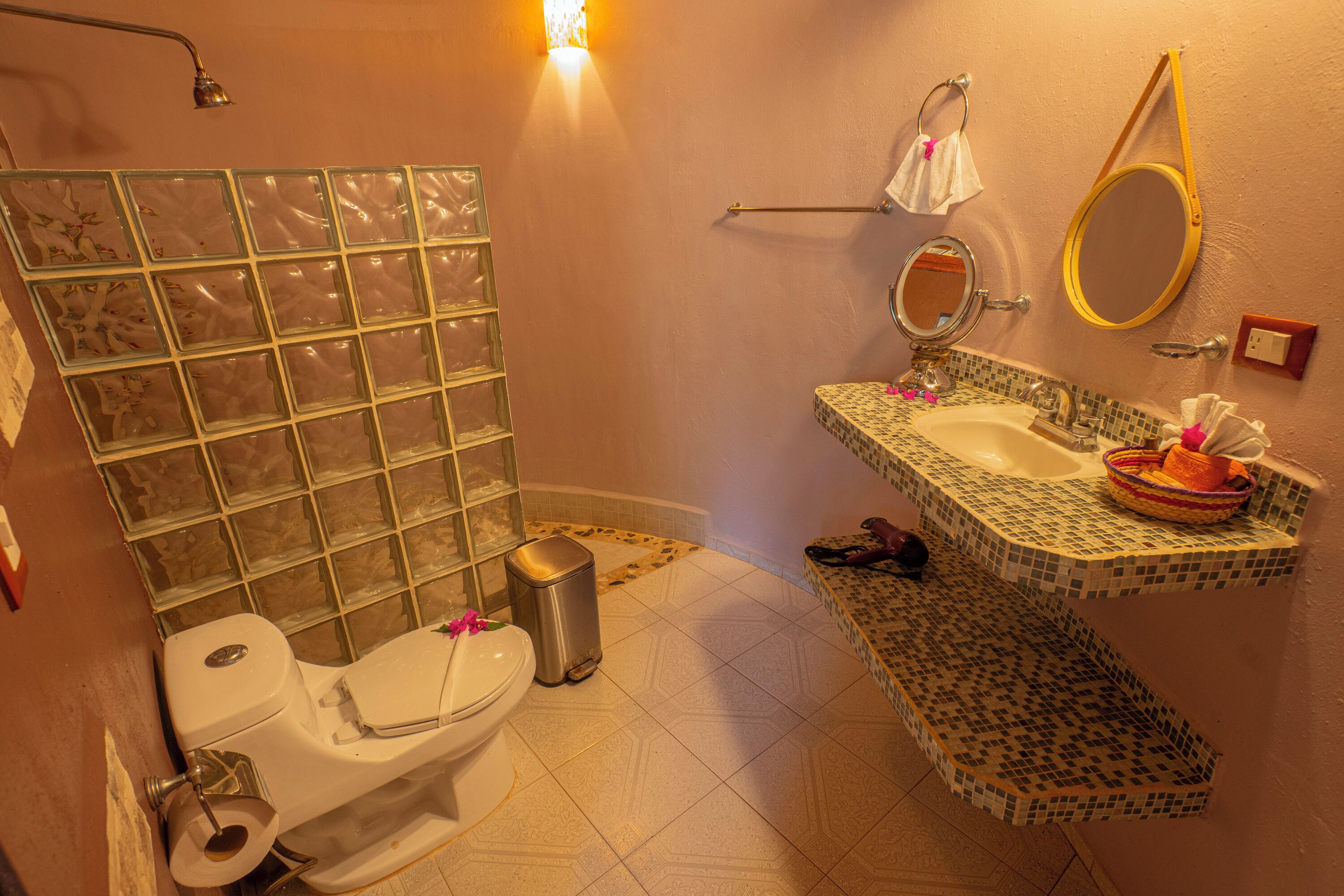 Un baño con inodoro, lavabo y ducha.