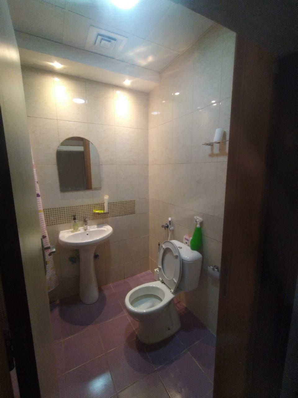 A small bathroom with a sink, toilet, and mirror.