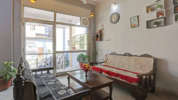 Een woonkamer met een bank, een salontafel en een groot raam met uitzicht op de straat.