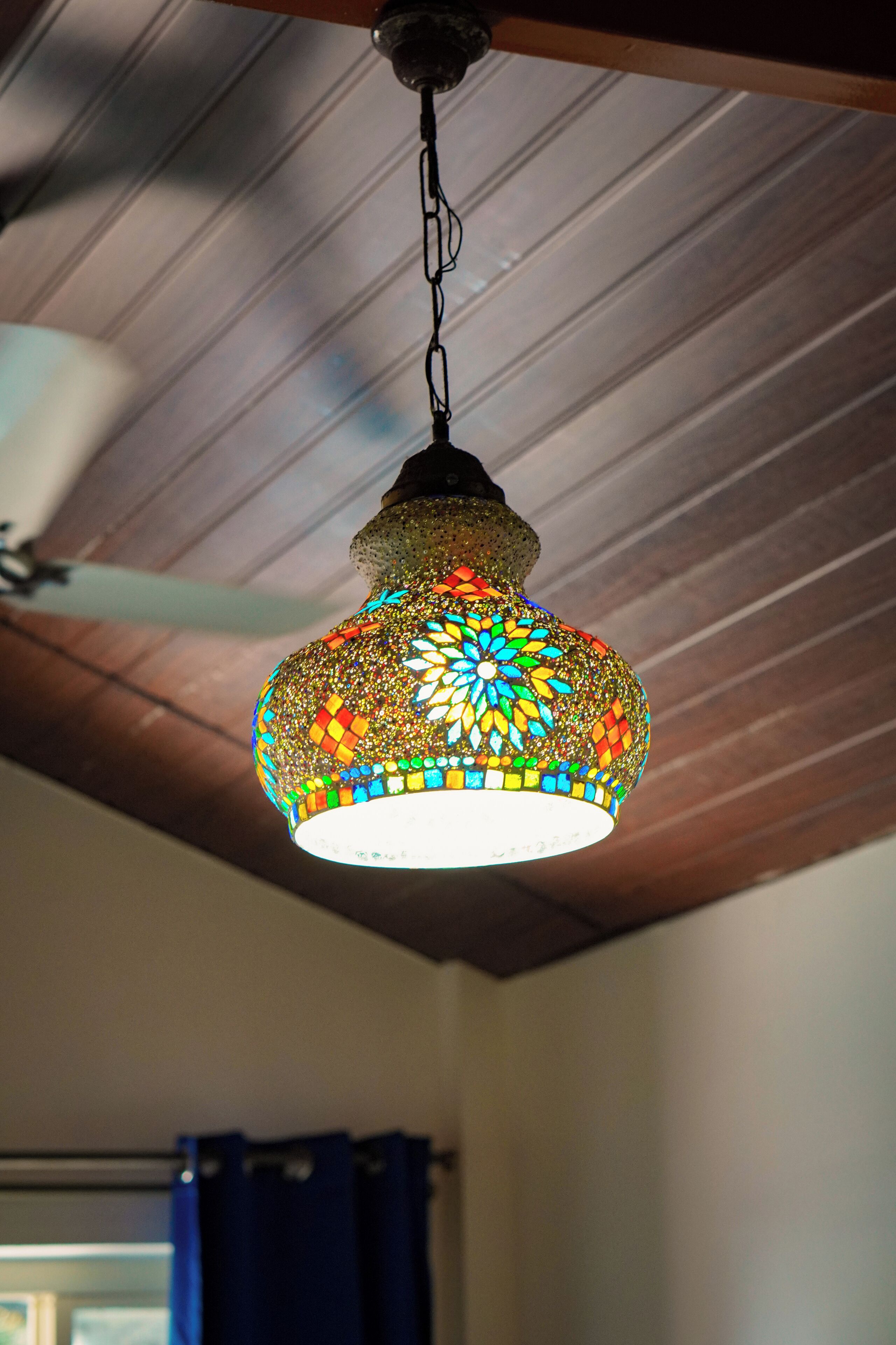 Een hanglamp met een mozaïek en een bloemenpatroon.