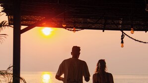 A couple walking on a wooden deck overlooking the ocean at sunset. - New Common Home (Canacona)