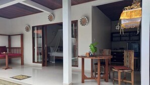 A covered outdoor area with a wooden table and chairs, a bench, and a decorative plant. - Hidden Point Villa 5 minutes to rice field walk. 1BD with Pool Walk to Ubud 

 (Bali)