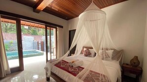 A spacious bedroom with a large bed, a canopy, and a view of a pool through the sliding glass doors. - Hidden Point Villa 5 minutes to rice field walk. 1BD with Pool Walk to Ubud 

 (Bali)