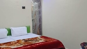 Ein Schlafzimmer mit einem Bett, einem Deckenventilator und einer wandmontierten Lampe.