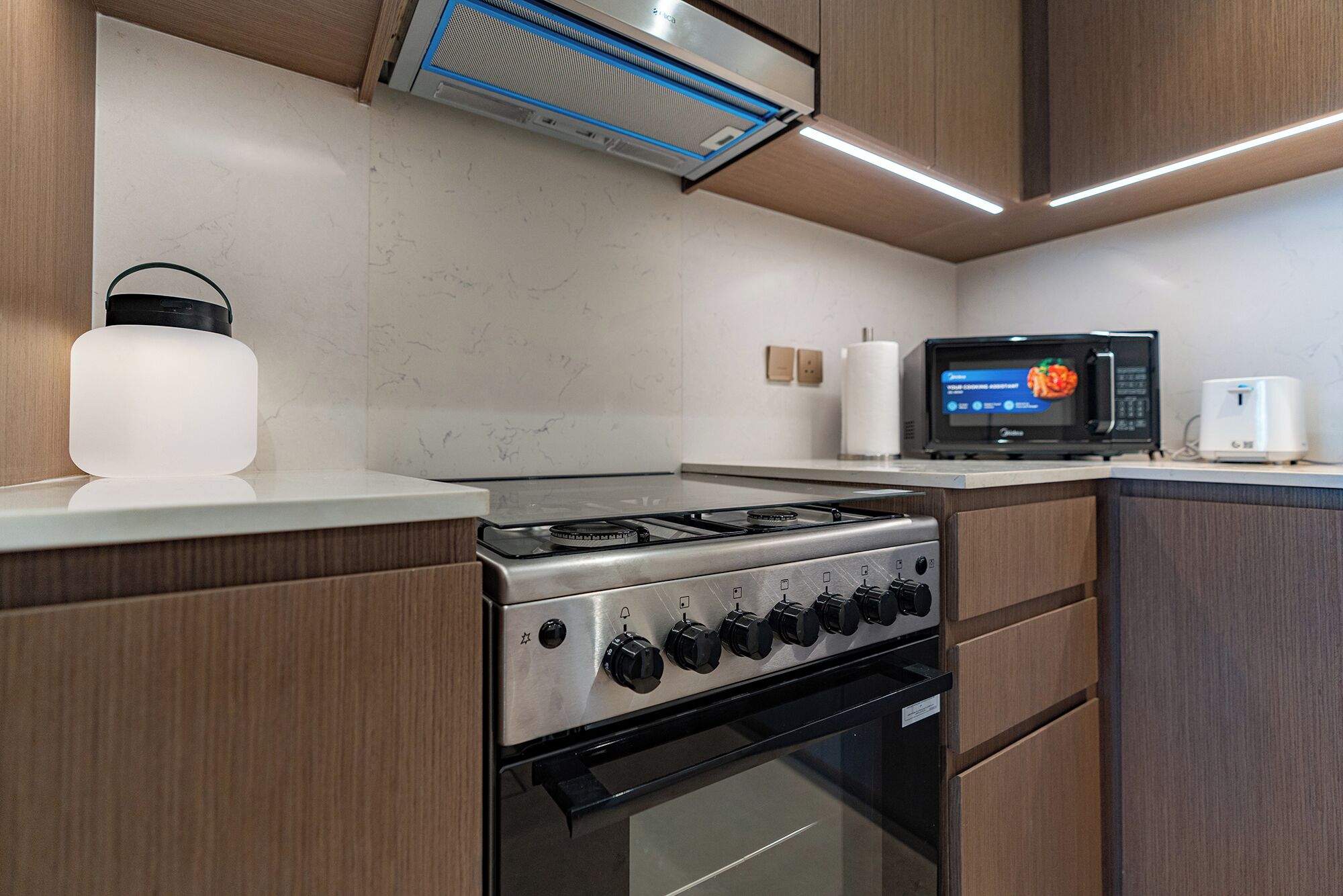 A modern kitchen with a stainless steel stove, a microwave, and a built-in oven.