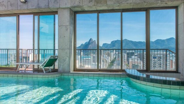 A rooftop swimming pool with a view of mountains and a cityscape. - Renovated aparthotel located in the vibrant Ipanema district of Rio de Janeiro.  (Ipanema Rio de Janeiro)