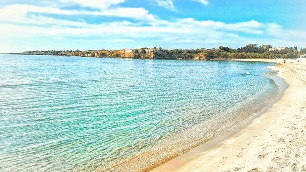 A beach with clear turquoise water and a sandy shore. - A Slice of Heaven by the sea - Beahost Rentals (Syracuse)