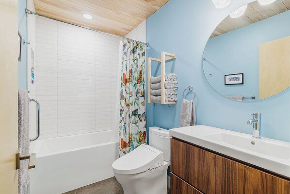 Un baño con bañera, inodoro y lavamanos.