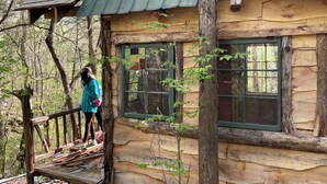 A rustic cabin with a wooden deck and large windows. - Unplug and hide from the world in this rustic South Pittsburg cabin (South Pittsburg)