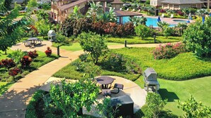 A residential area with a swimming pool, patio furniture, and well-maintained gardens.