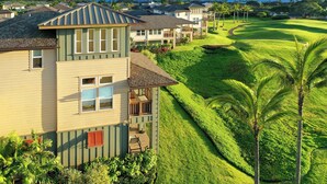 A residential area with houses, a well-maintained lawn, and a view of the ocean.